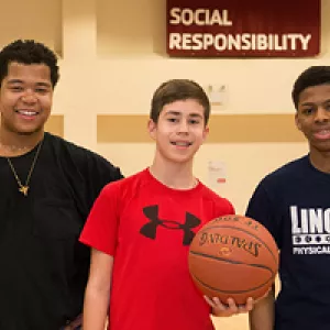 three teens with a basketball