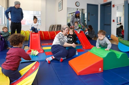 Families and children play in playroom at Bedstuy YMCA