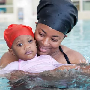 Mother holds daughter in Rockaway YMCA indoor pool mommy and me swim class