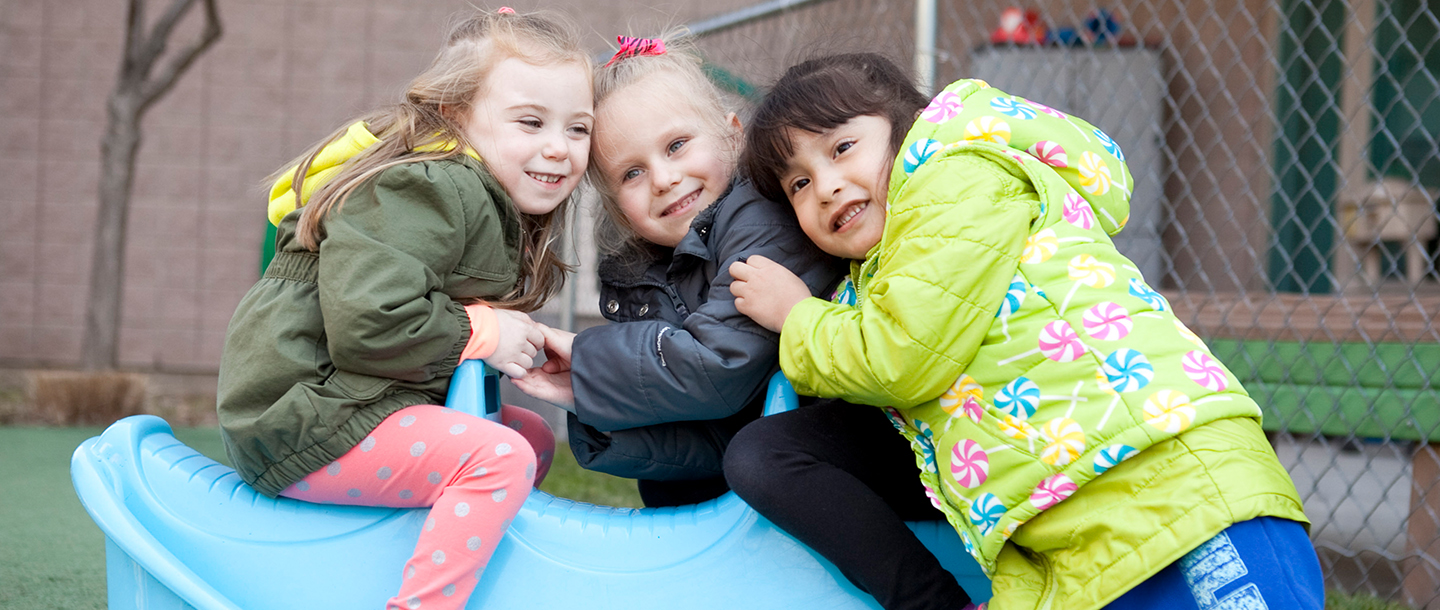Preschool girls playing outside at YMCA UPK program playground