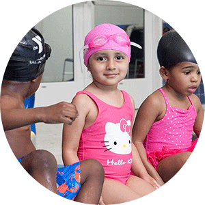 Preschool girl in swim lesson on side of pool
