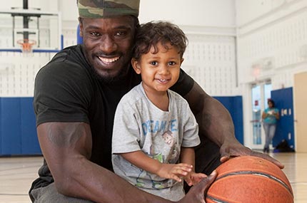 Dad with toddler son and basketball in Rockaway YMCA gymnasium