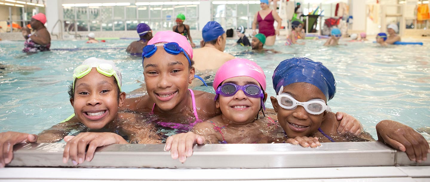 Four girls swimming at YMCA indoor pool
