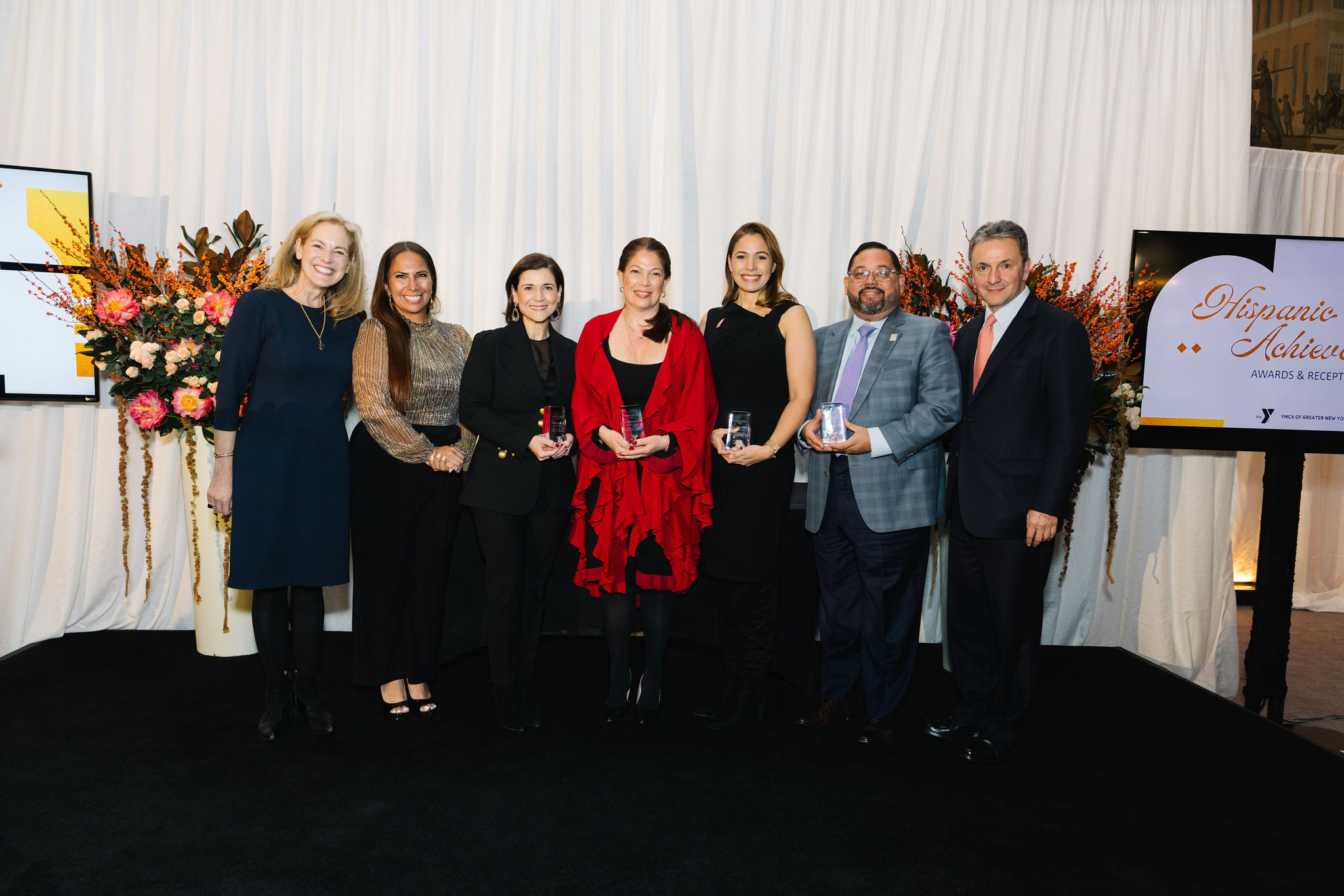 seven adults standing with awards