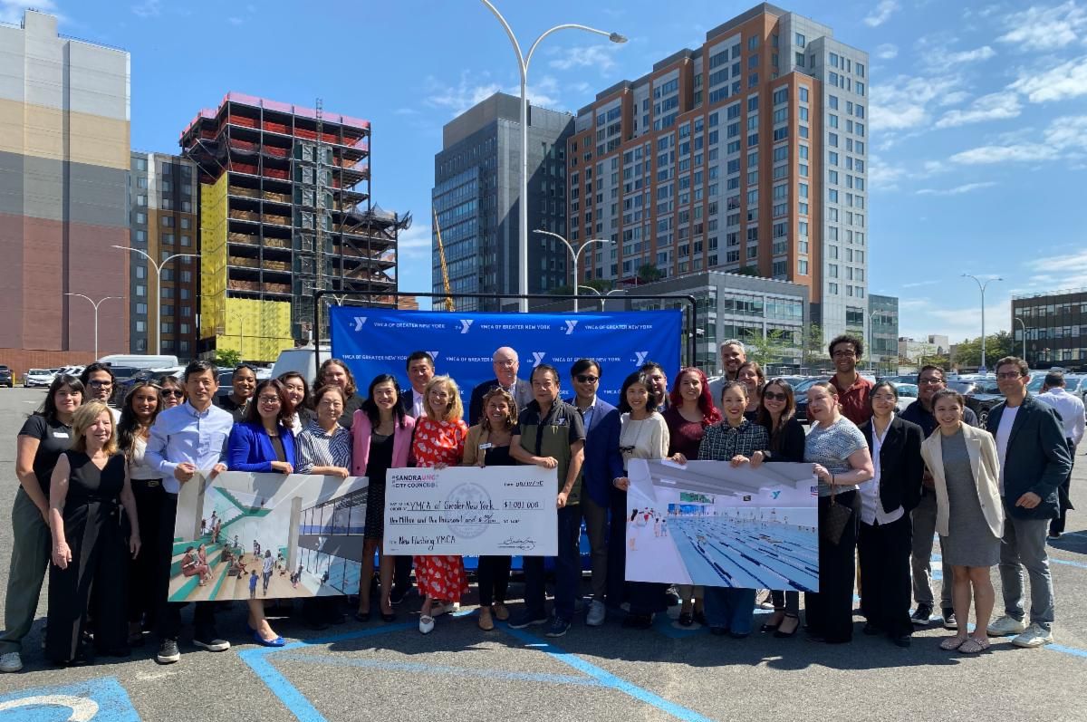 group photo holding signs in parking lot