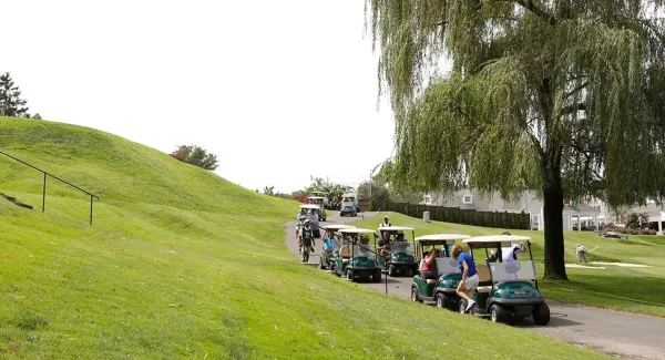 Group of golf carts along Long Island golf course hill