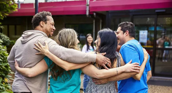 four people hug