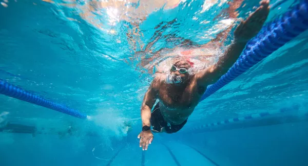 man swims in pool underwater