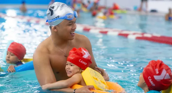 instructor holding child in pool