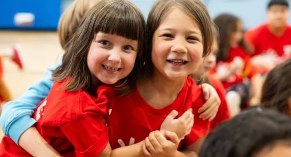 2 girls hug and smile