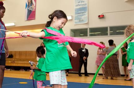Girl does gymnastic skills during summer camp at YMCA in Manhattan