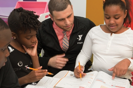 Students work with YMCA staff on homework at Y Afterschool