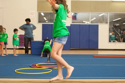 Kids learning gymnastics skills during youth sports class at the YMCA