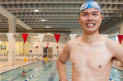 Adult learning to swim in class in pool at YMCA