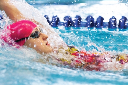 A young swimmer swims the back stroke.