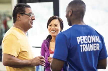 A YMCA personal trainer works with two Y member.