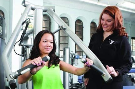 A YMCA personal trainer works with a Y member.