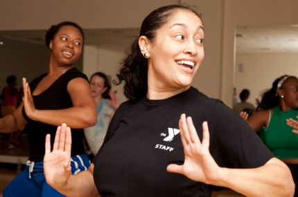 A YMCA instructor leads a group fitness class.