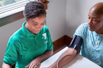 A Y staff member takes a visitor's blood pressure.
