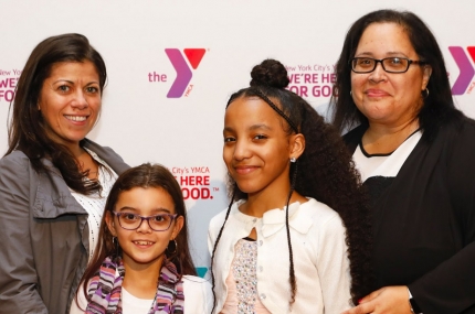 A family in front of a Y photo wall at the Arts & Letters reception.