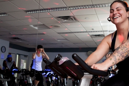 A woman instructor on a spin bike in the YMCA.