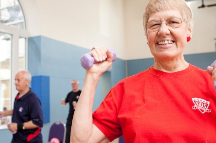 A senior woman with dumb bells at the YMCA.