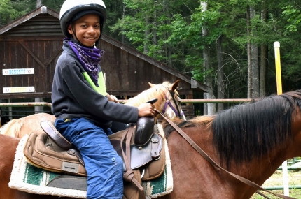 A child on a horse at the YMCA Sleepaway Camp.