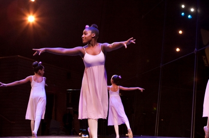 Kids dancing on staging during a performance at the YMCA.