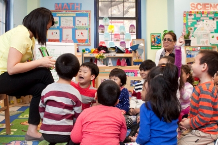 Kids clustered around a teacher during UPK.