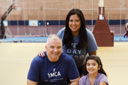 Family playing in gym together with basketball at YMCA