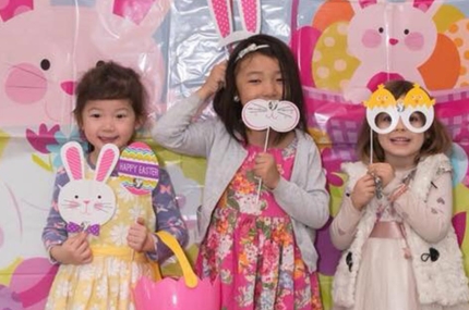 Three preschool girls with Easter egg baskets and bunny masks