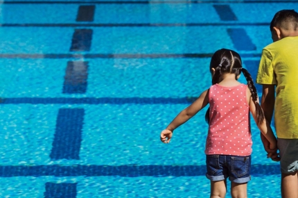 Two kids looking into pool