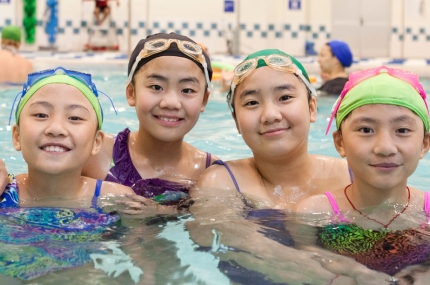 Four girls swimming in Coney Island YMCA indoor pool in Brooklyn