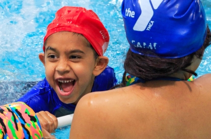 Boy learning how to swim at indoor YMCA pool