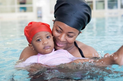 Mother holds daughter in Rockaway YMCA indoor pool mommy and me swim class