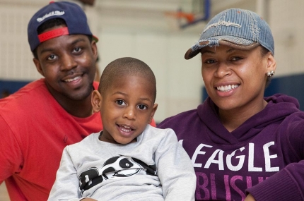 Family sitting at Rockaway YMCA indoor basketball court