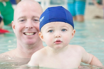 Dad with baby swimming at YMCA indoor pool