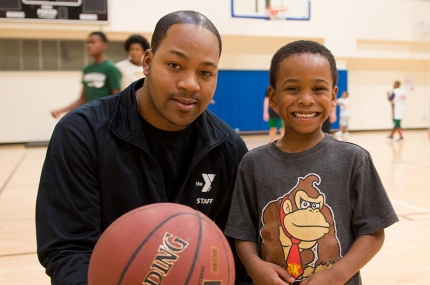 Young boy with basketball instructor at YMCA