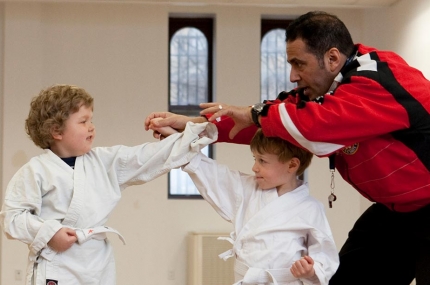 Two boys doing karate moves with instructor at YMCA studio