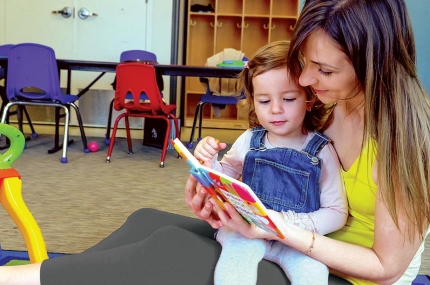 Mom reading to baby at YMCA reading room