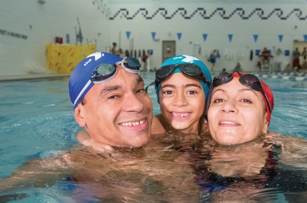 Family swimming in pool at YMCA