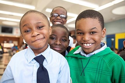 Group of boys smiling at YMCA afterschool program in NYC elementary school