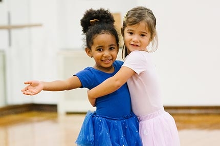 Two ballerinas hug