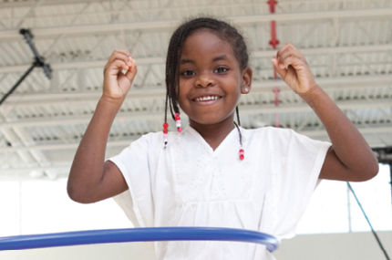 young girl hula hoops in YMCA gym