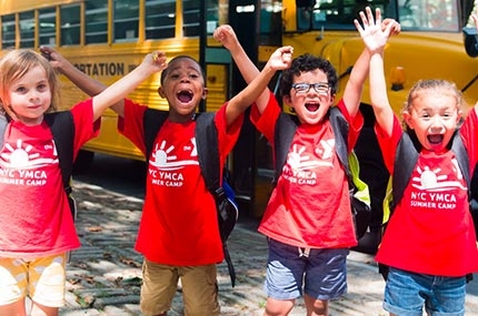 Summer campers with arms up on YMCA field trip