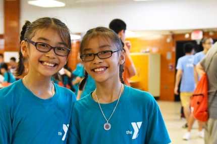 Two teenage girls smiling at the Chinatown YMCA summer day camp.