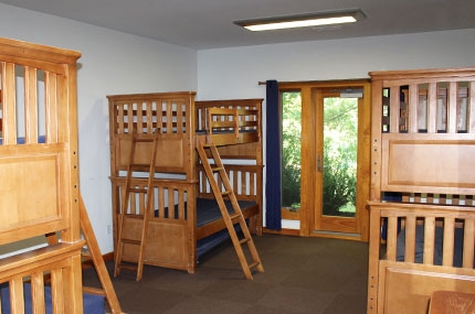 A room with 4 bunkbeds at the YMCA Sleepaway Camp.