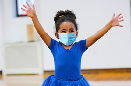 A girl in a mask at ballet class at the YMCA