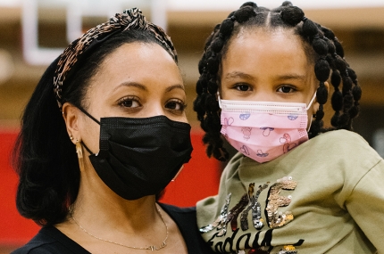 Mother and Daughter posing in masks inside a gym
