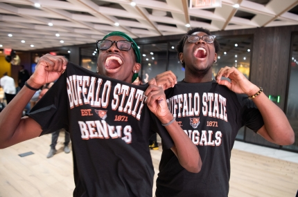 two teens showing off their college tshirts